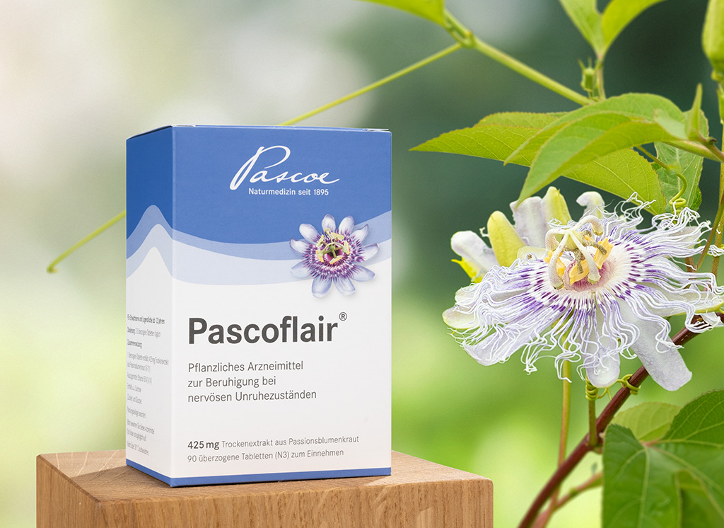 Abbildung Produkt Pascoflair auf einem Holzblock neben einer Passionsblumenpflanze