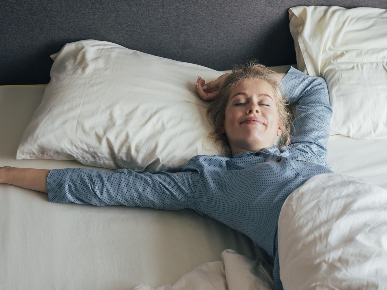 Schlafhygiene: Frau wacht erholt auf