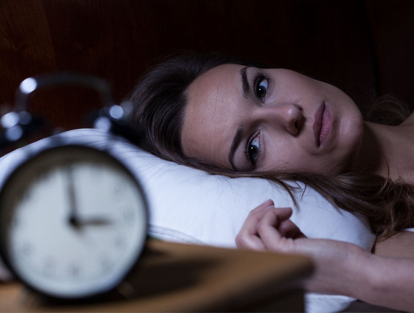 Frau schaut nachts auf den Wecker- Schlafstörungen