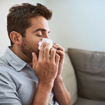 Mann putzt sich die Nase aufgrund einer Allergie