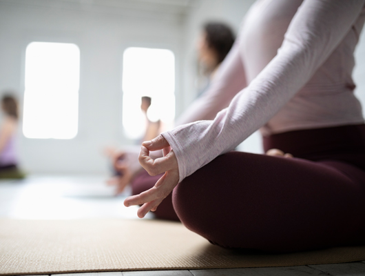 Frau macht Yoga gegen Menstruationsbeschwerden
