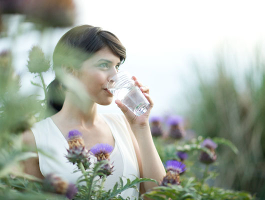 Frau trinkt Wasser, um eine Harnwegsinfektion vorzubeugen